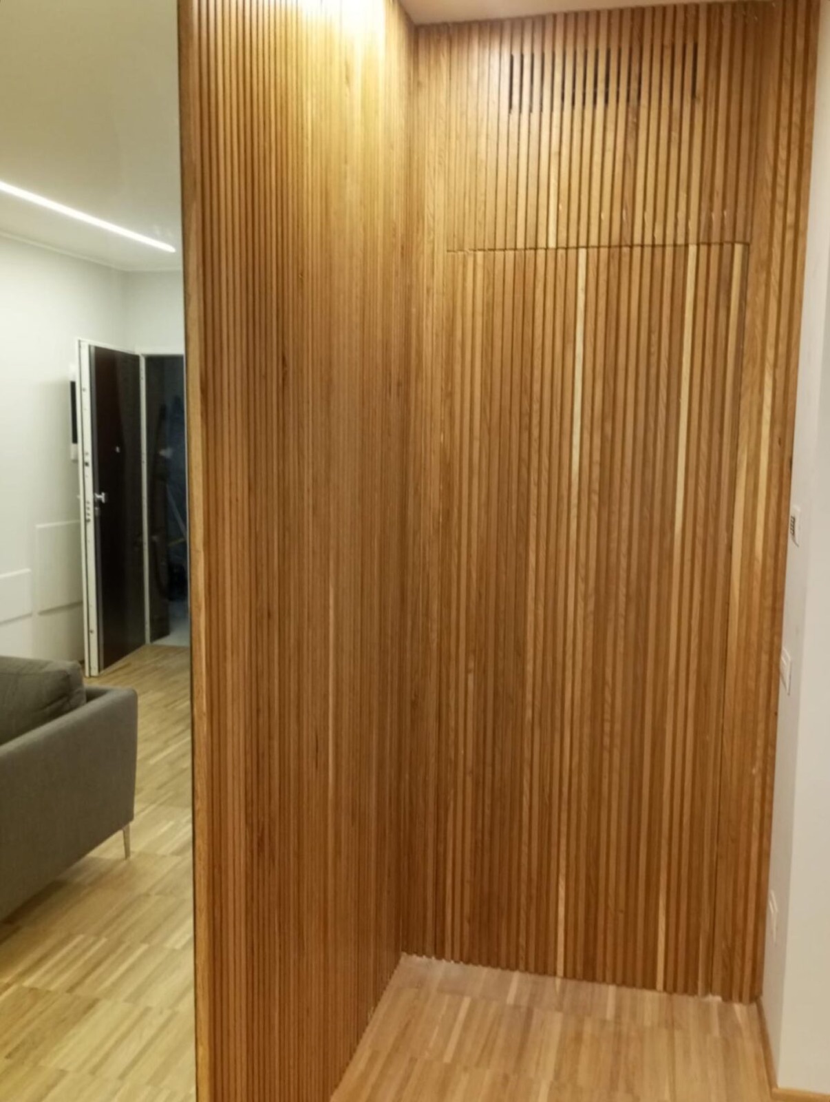 Parete a listelli in rovere realizzata su misura