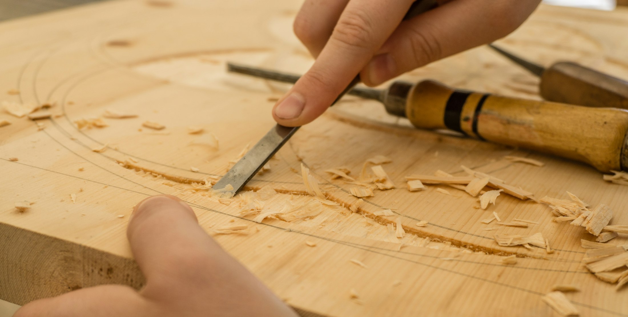Mani che intagliano il legno con lo scalpello